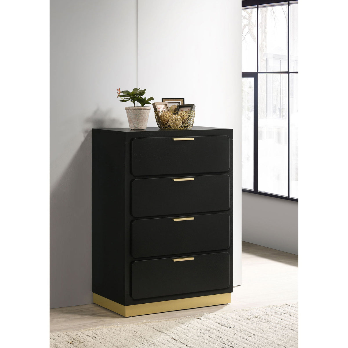 Black four-drawer chest with gold bar handles and tapered base