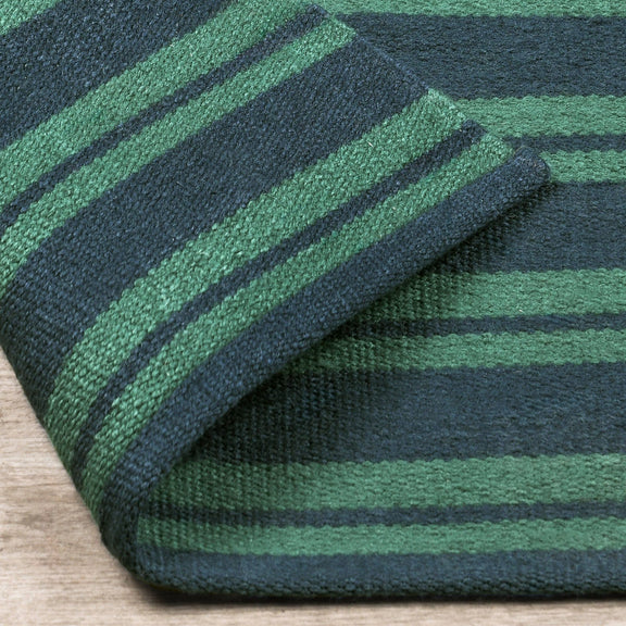 Striped rug corner detail, green and dark-blue bands