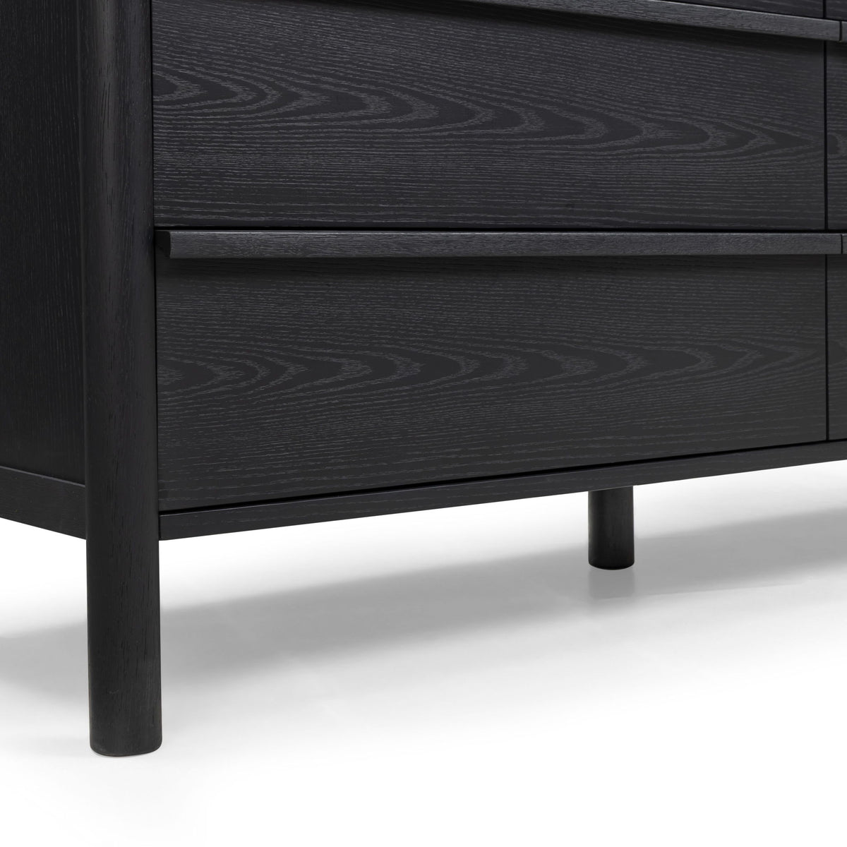 Black wood dresser showing two drawer fronts with subtle wood-grain pattern
