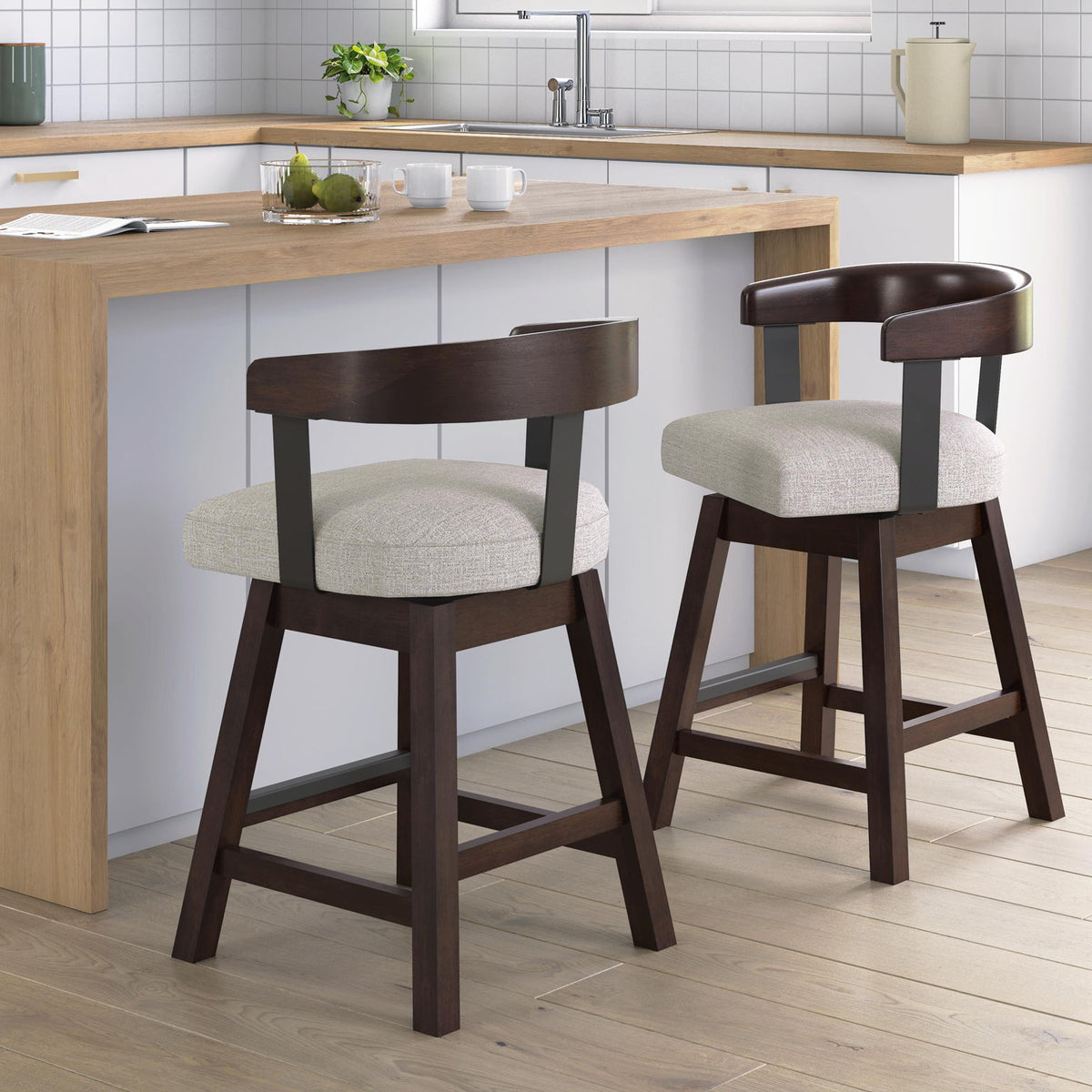 Two upholstered barstools with dark brown frames and grey fabric seats at a kitchen island