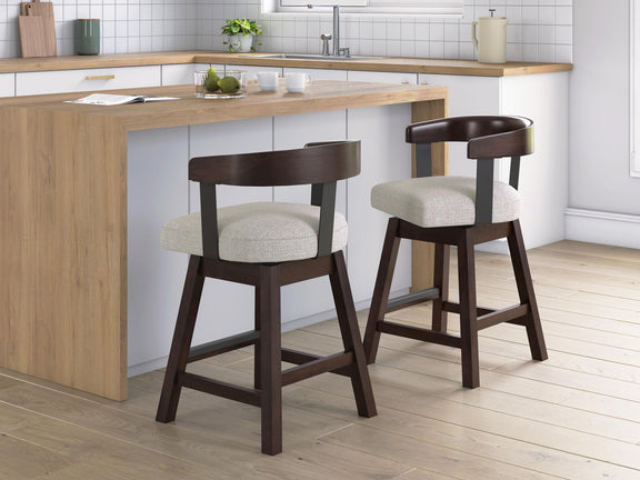 Two upholstered barstools with dark brown frames and grey fabric seats at a kitchen island
