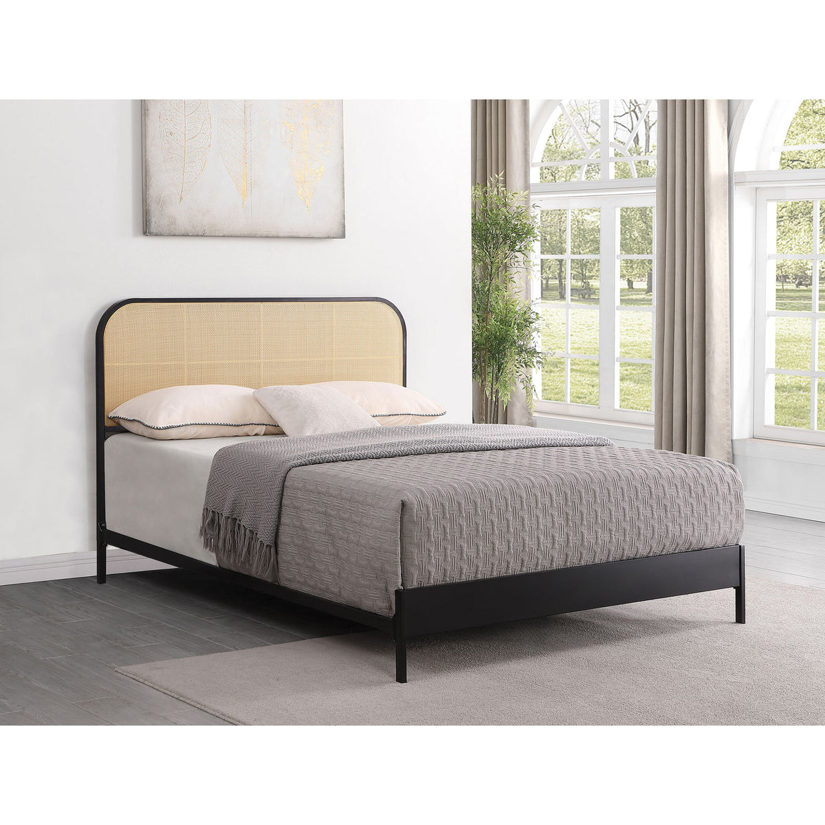 Black bed with tan arched headboard, fabric panel, and slatted base.