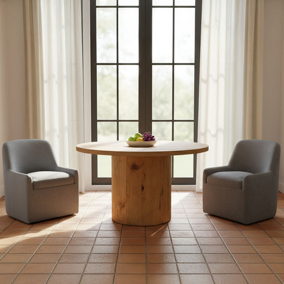 Upholstered slate blue dining chair with rounded arms and back, shown beside a table