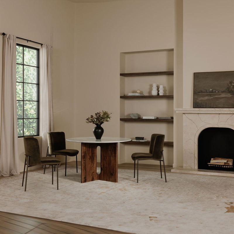 Green upholstered dining chairs with padded seats and slim metal legs around a dining table