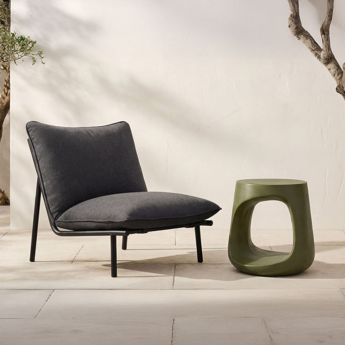 Dark green sculptural outdoor stool with large cutout oval opening