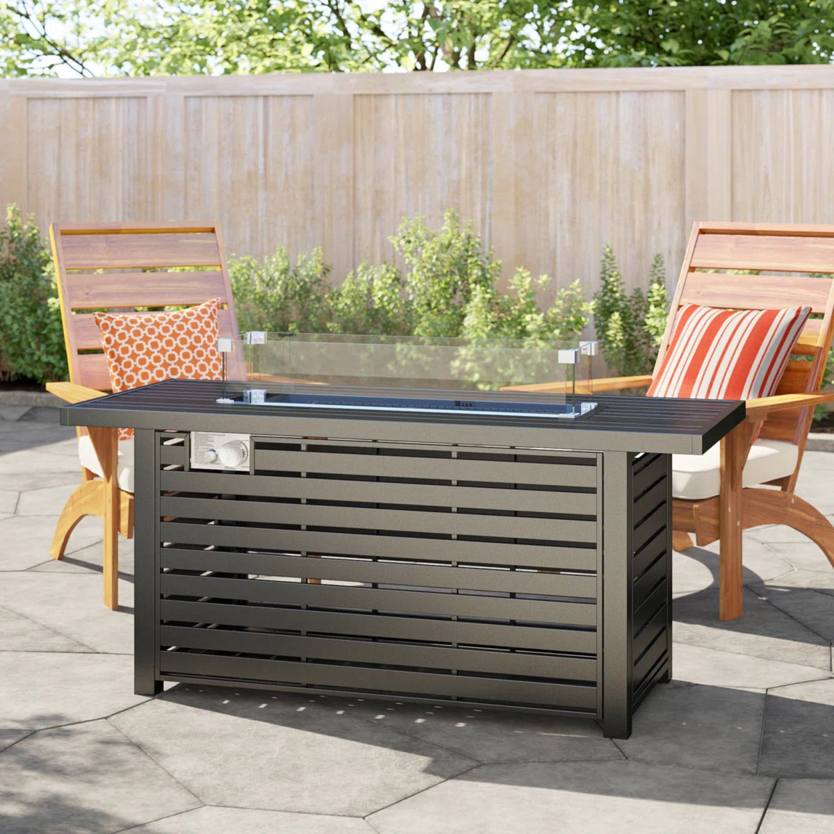 Black propane fire pit table on patio with glass wind guard and open flame