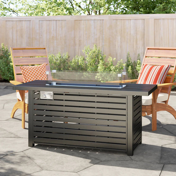 Black propane fire pit table on patio with glass wind guard and open flame