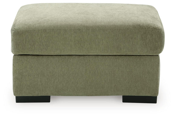Green upholstered ottoman with rounded top and dark block feet