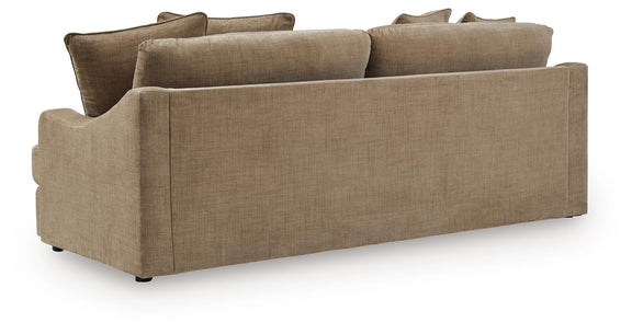 Beige fabric sofa back and arm view with multiple throw pillows