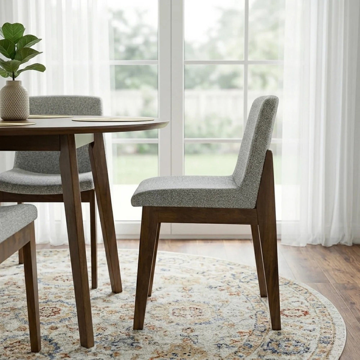 Gray upholstered dining chair with dark wood legs, angled view