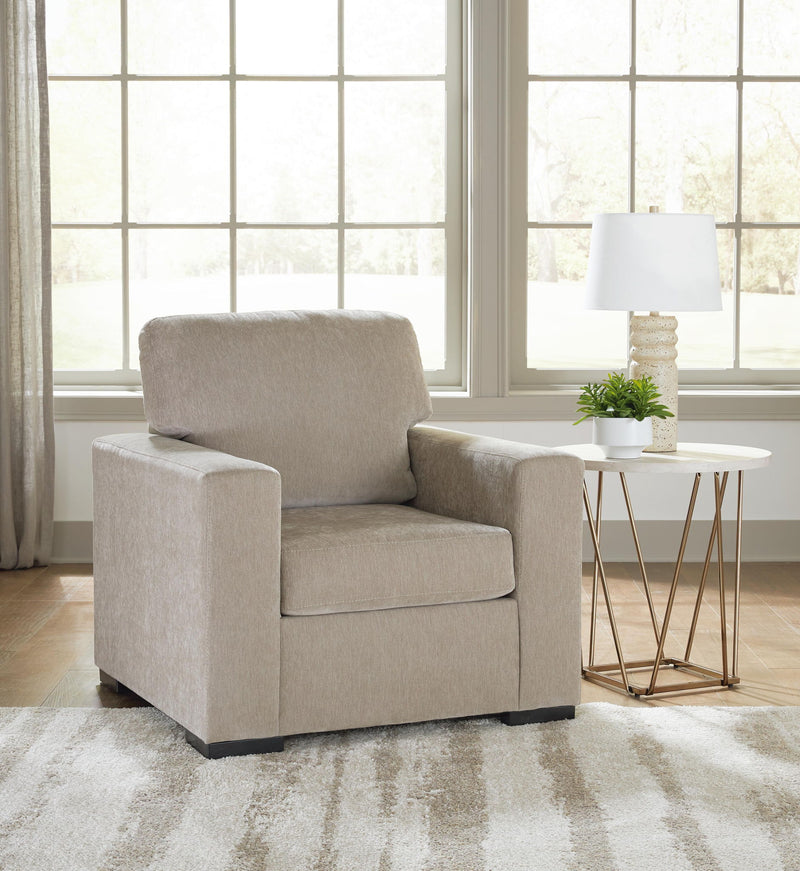 Light brown lounge chair with thick armrests and back cushion; dark legs visible below.