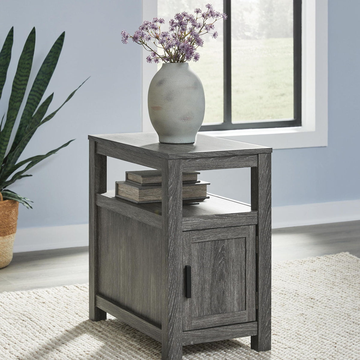 Chair side end table in dark gray wood with drawer-style cabinet door and shelf