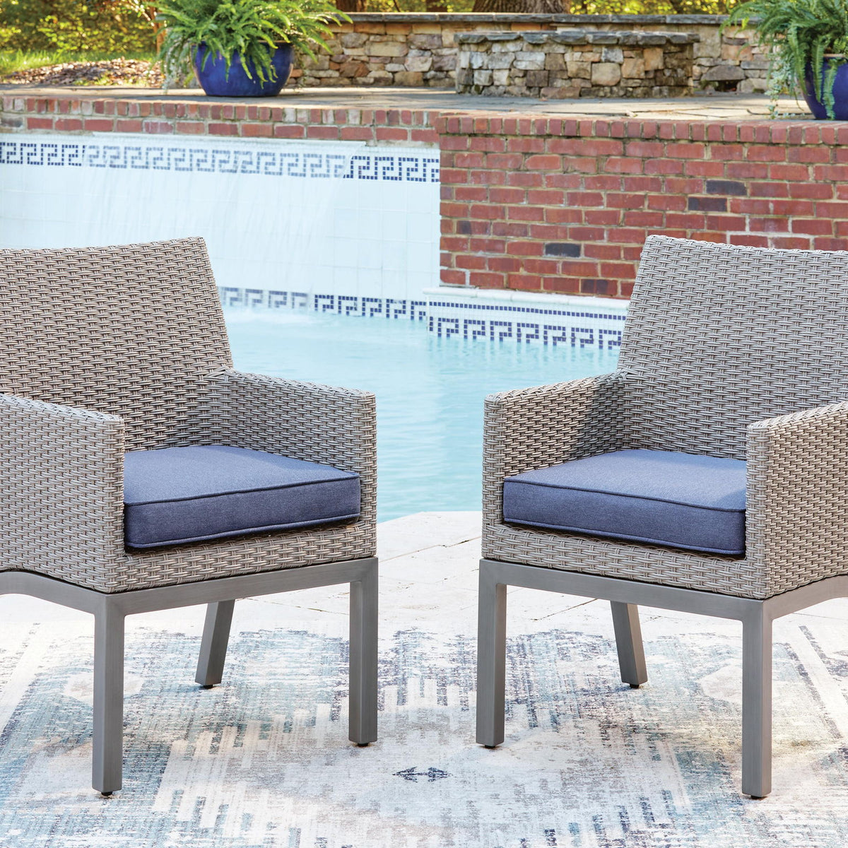 Woven arm chairs with blue cushions and gray frames, two chairs shown