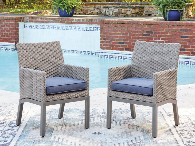 Woven arm chairs with blue cushions and gray frames, two chairs shown