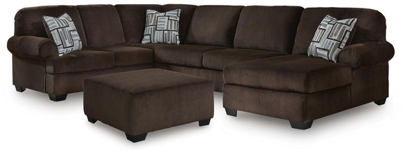 Dark brown sectional sofa with corner chaise, ottoman and three patterned throw pillows