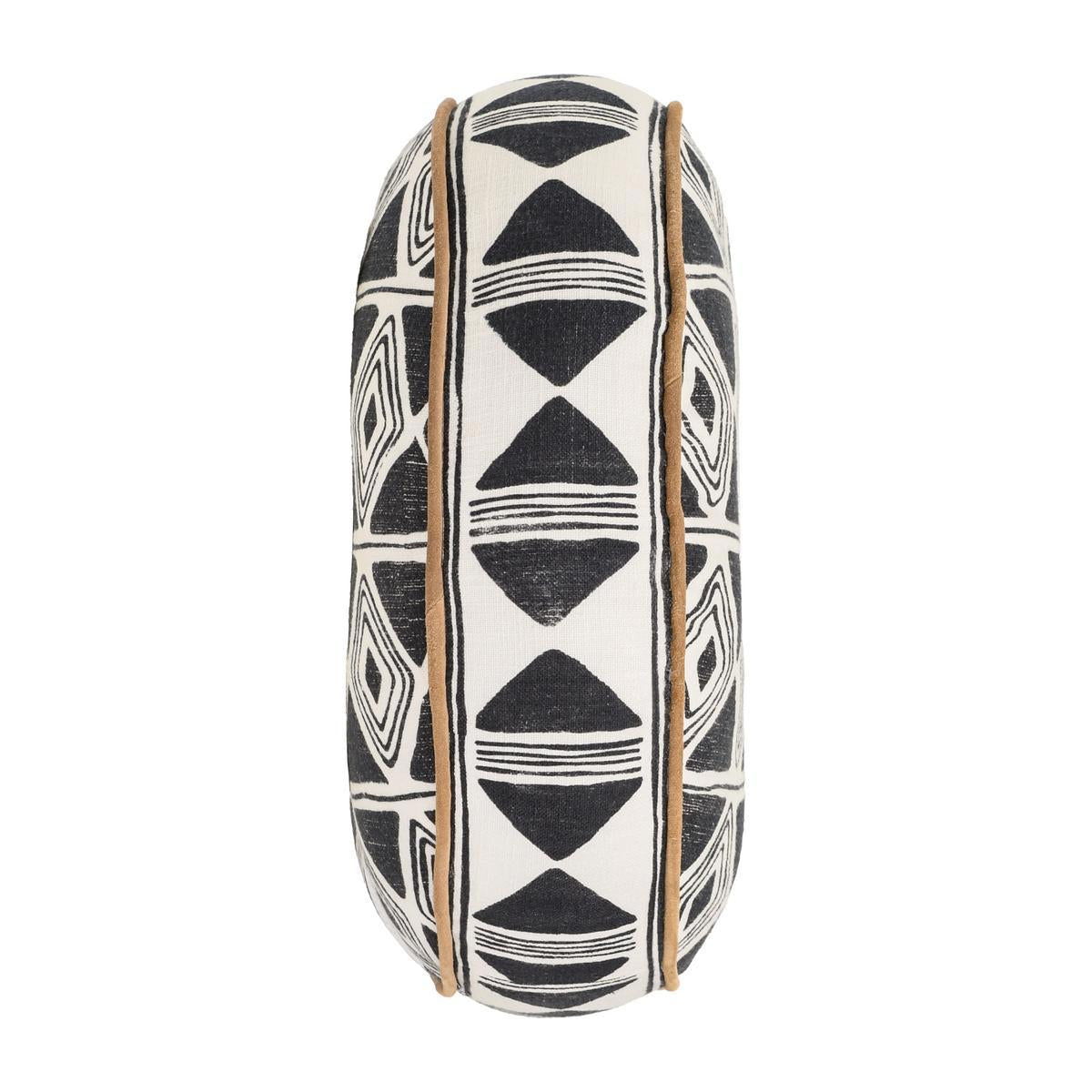 Black and white geometric patterned square pillow with tan piping, side view