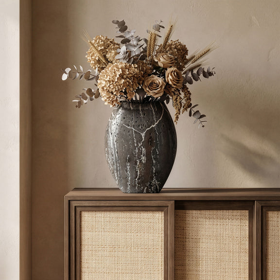 Dark gray textured vase holding a mixed floral arrangement