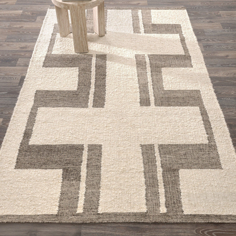 Geometric area rug in cream with charcoal cross pattern and fringed border