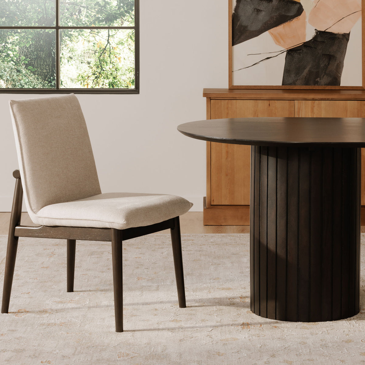 Beige upholstered dining chair with dark legs, straight back and padded seat