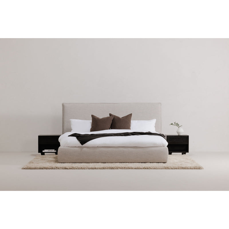 Light gray king bed with white duvet, dark pillows, and black side drawers