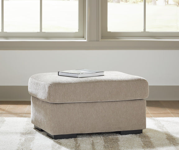 Light brown upholstered ottoman with rounded seat and dark legs