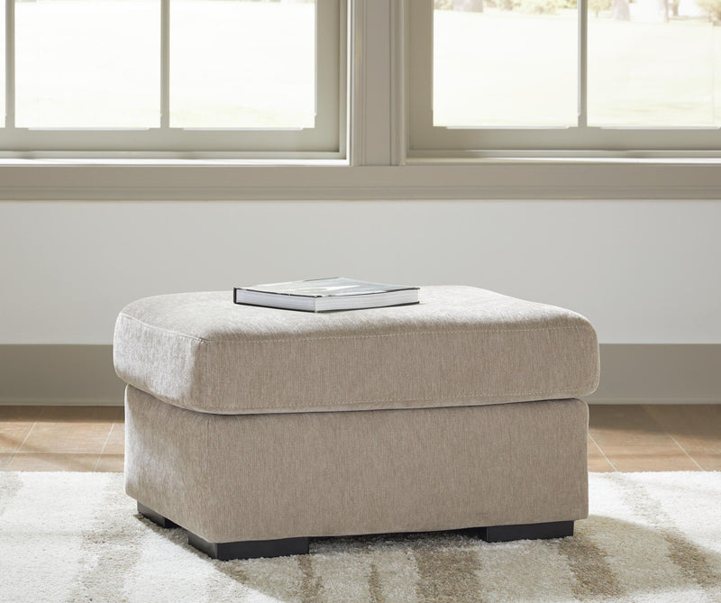 Light brown upholstered ottoman with rounded seat and dark legs