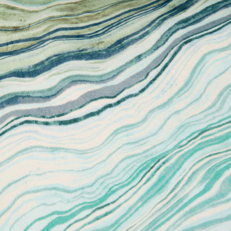 Pillow fabric close-up: teal, light blue, and white wavy lines