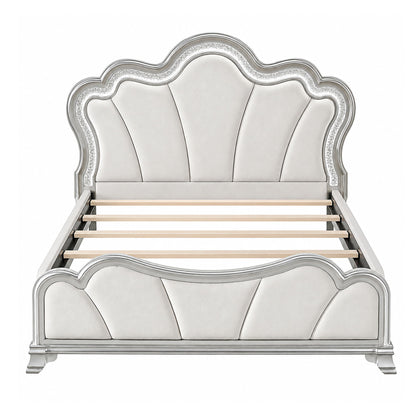 Silver upholstered platform bed with tufted panel headboard and curved footboard