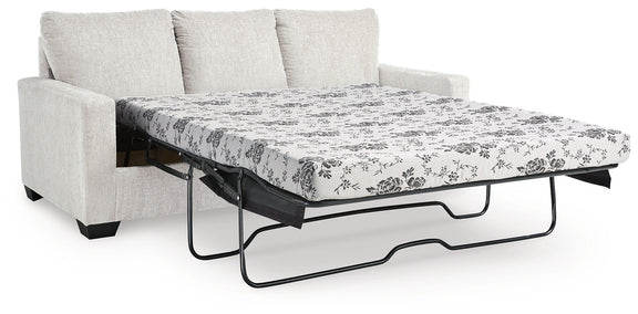 Beige sofa with pull-out bed frame and white floral patterned mattress cover