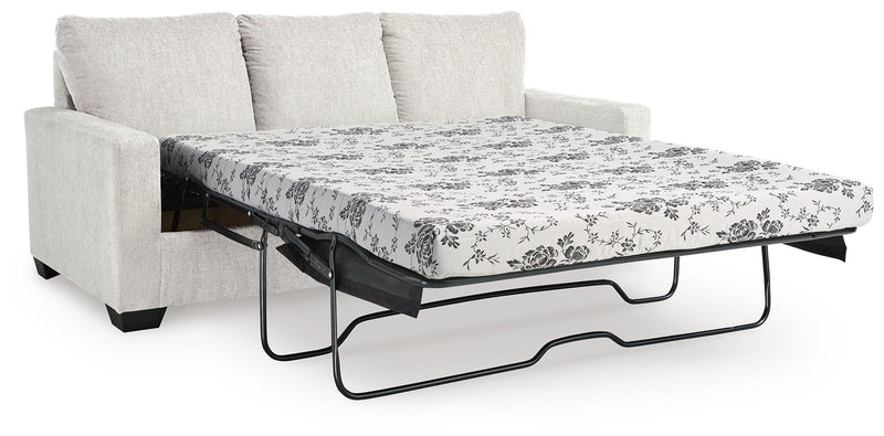 Beige sofa with pull-out bed frame and white floral patterned mattress cover