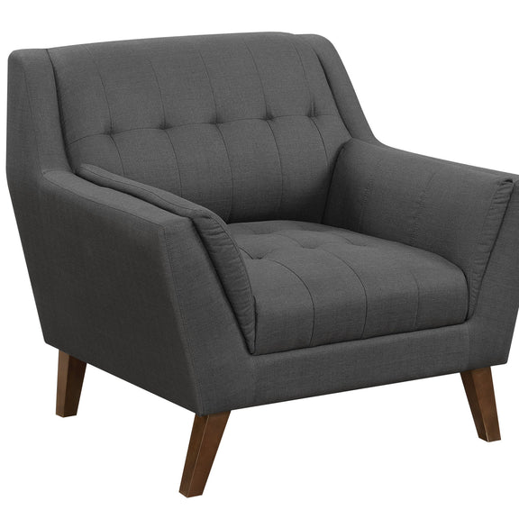 Dark gray accent chair with tufted back, padded arms, and wooden legs