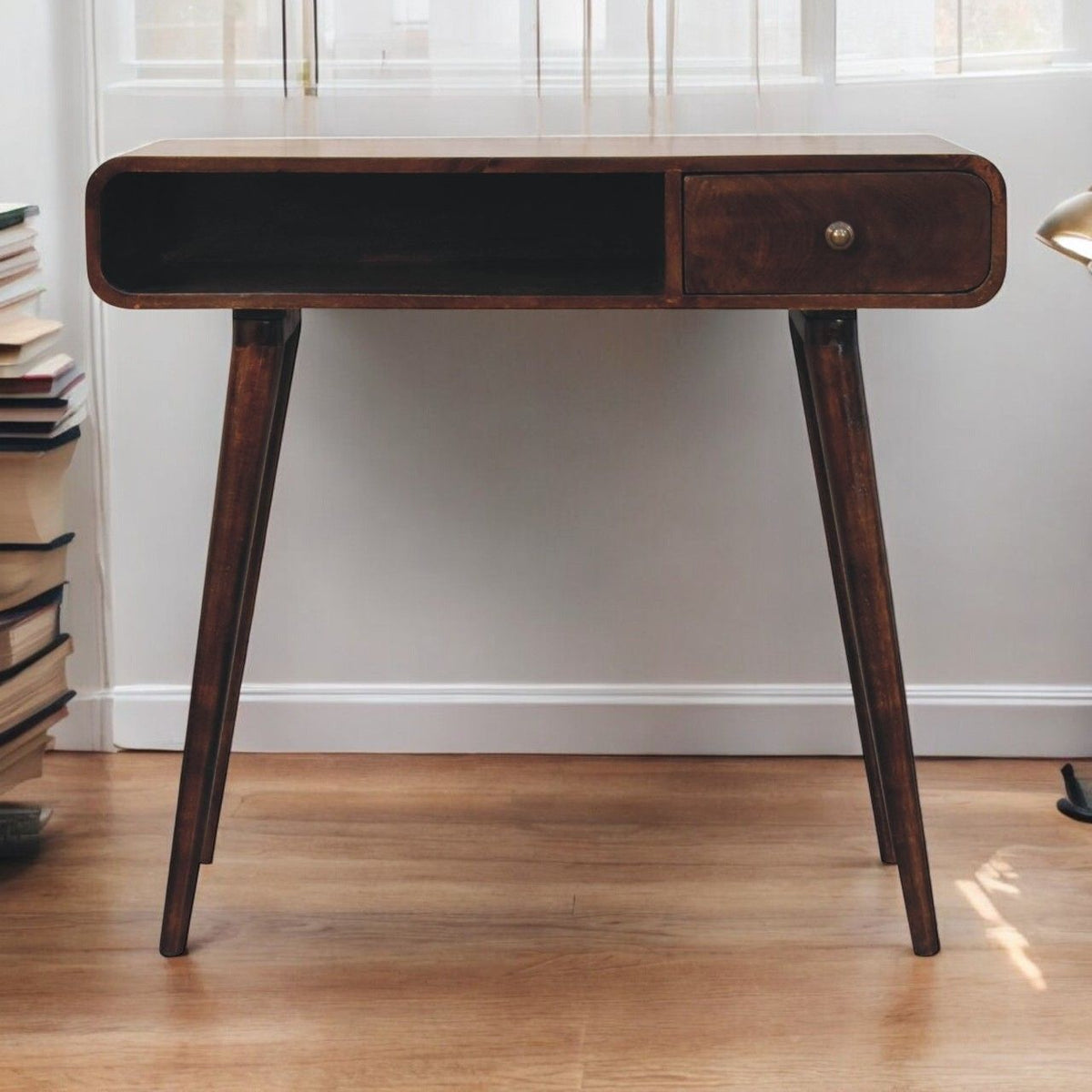 Curved writing desk front view: dark open storage and single wooden drawer on brown legs