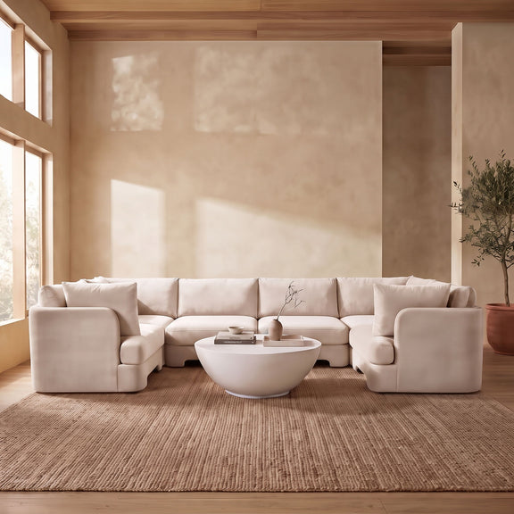 Beige velvet U-shaped sectional sofa styled in a living room