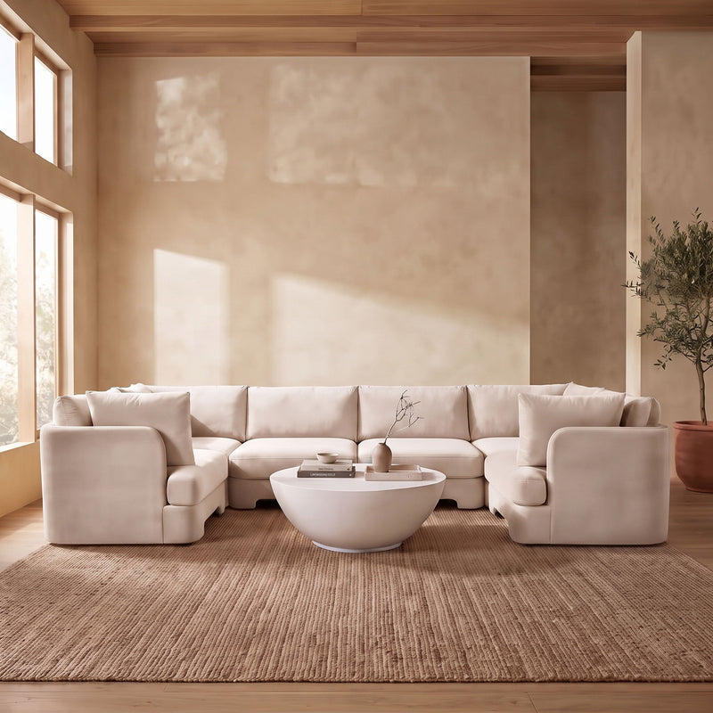 Beige velvet U-shaped sectional sofa styled in a living room