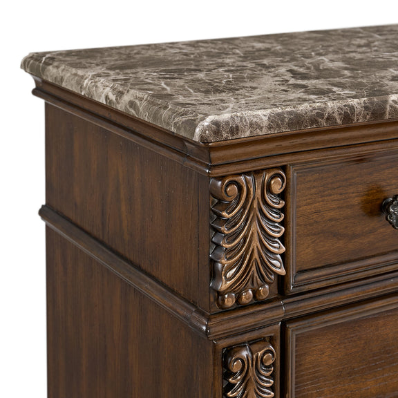 Brown wooden chest with ornate metal leaf corner details and textured top