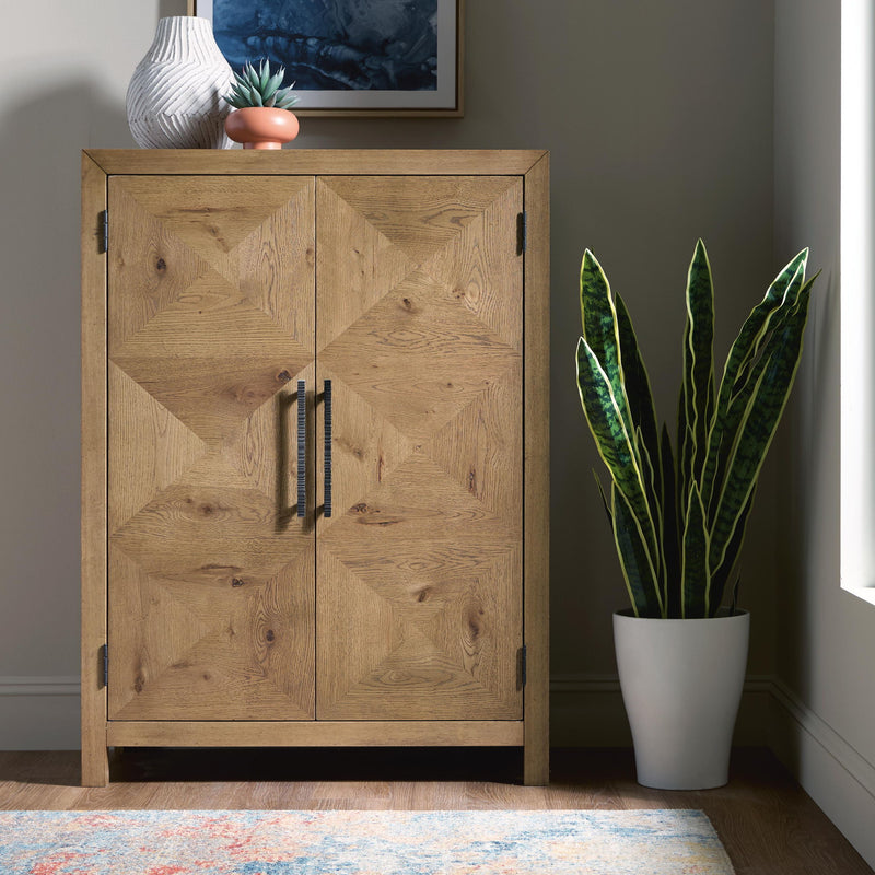 Light brown bar cabinet with two panel doors and vertical bar handles, angled view