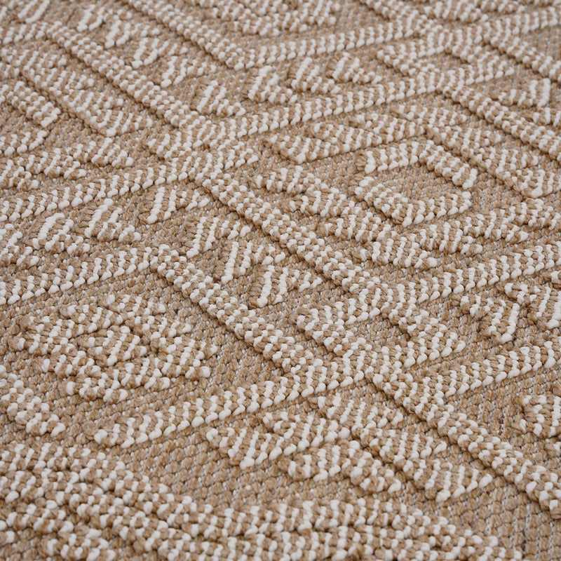 Light brown rug close-up with raised looped texture and repeating geometric motif.