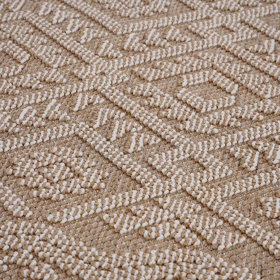 Traditional area rug close-up, light brown looped texture with woven geometric motif