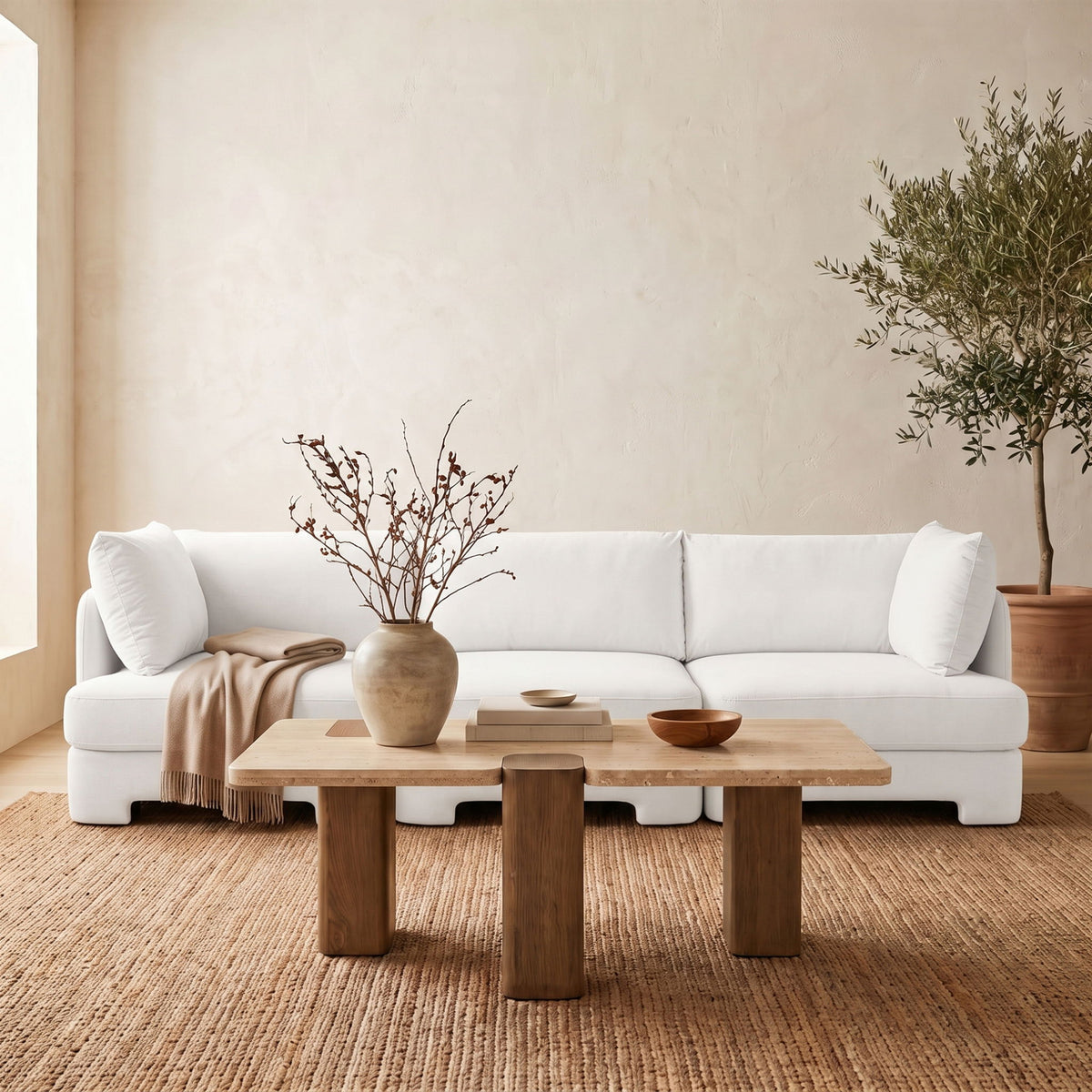 White upholstered 3-piece velvet sofa with back cushions and throw blanket draped