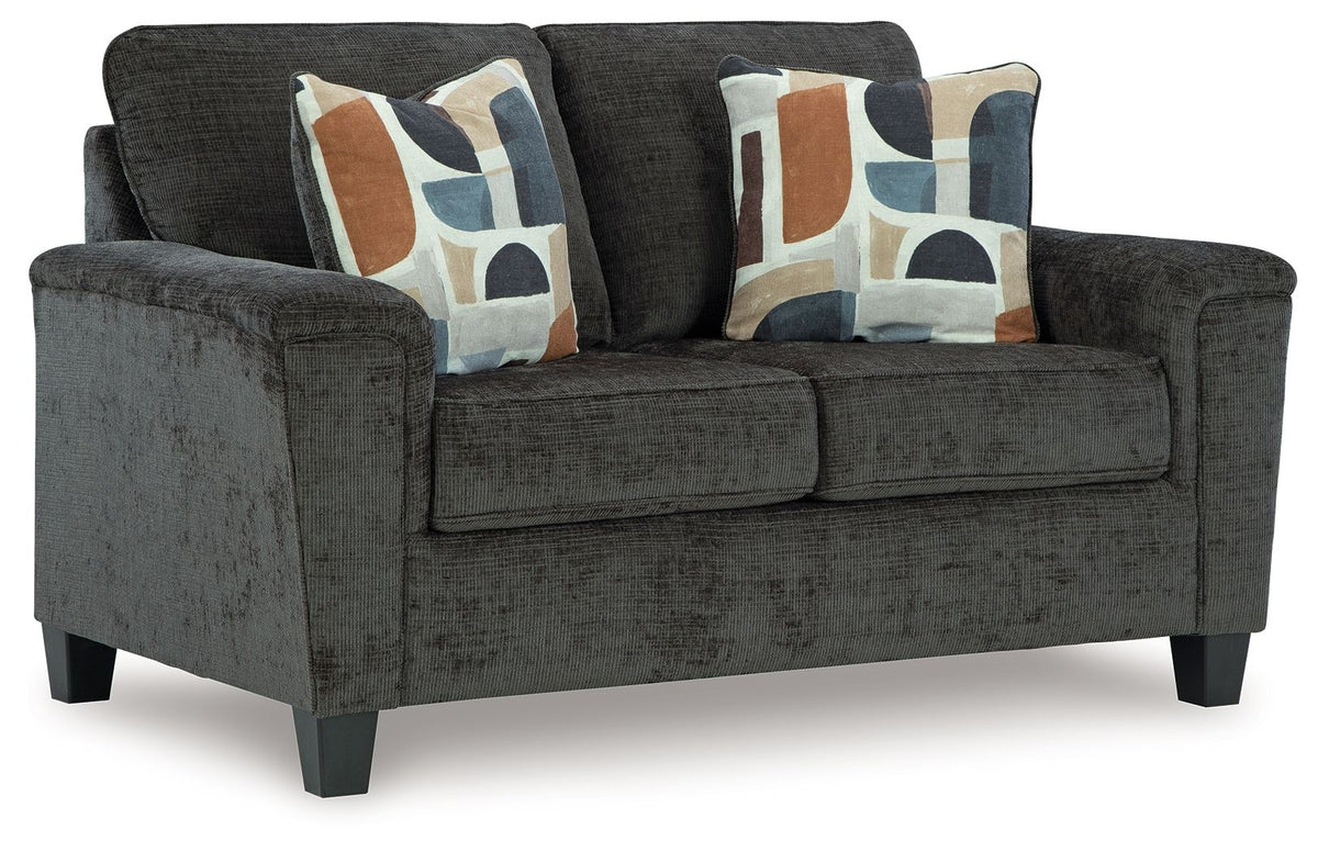 Dark charcoal loveseat with rolled arms, square seat, and two geometric throw pillows