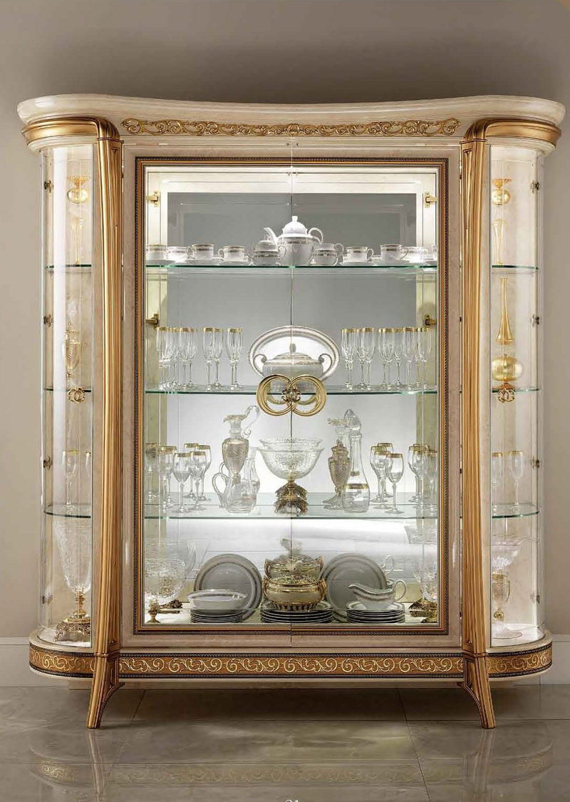 Beige and gold 4-door glass display cabinet with ornate trim and mirrored shelves