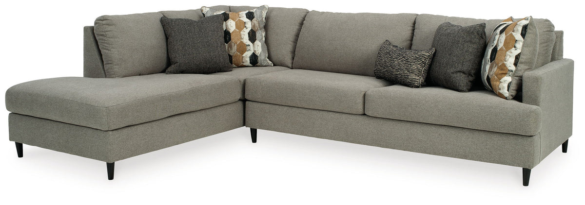 Gray chaise sectional sofa with dark accent pillow and patterned lumbar pillow.