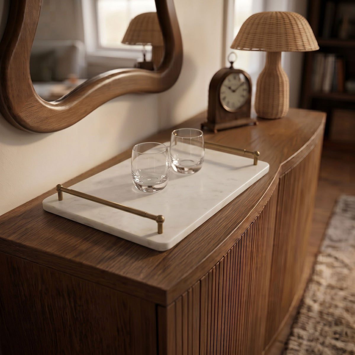 Marble serving tray with corner posts holding two clear glasses on a side table