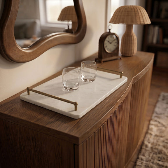 Marble serving tray with corner posts holding two clear glasses on a side table