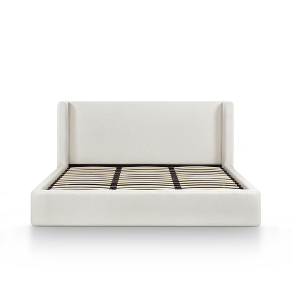 White upholstered bed frame with slatted mattress and black-and-white striped cover