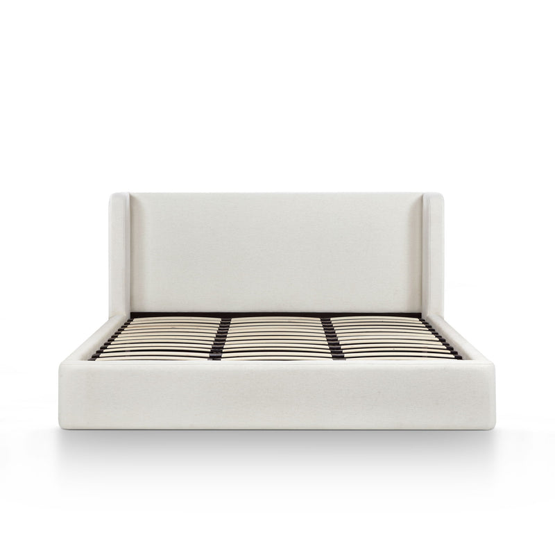 White upholstered bed frame with slatted mattress and black-and-white striped cover