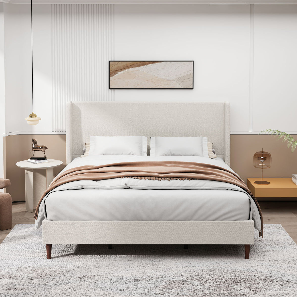Beige upholstered bed styled with white bedding and pillows