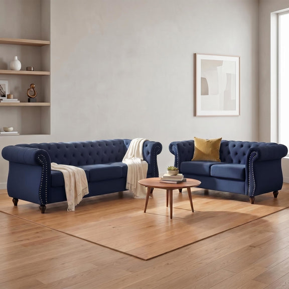 Blue tufted loveseat set with rolled arms, nailhead trim, and two upholstered seats.