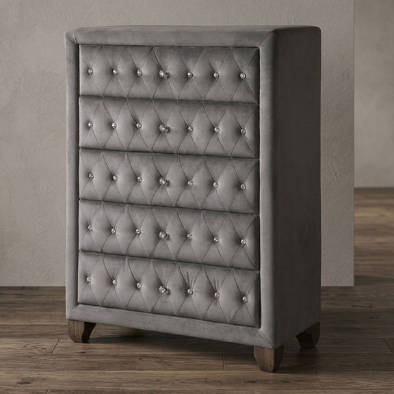 Gray tufted 5-drawer chest with silver stud accents and angled feet