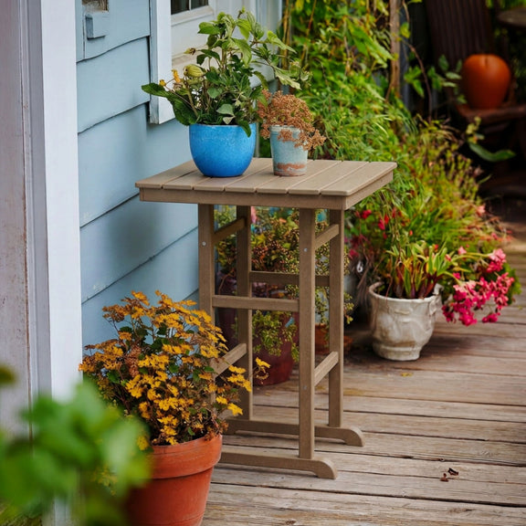Outdoor bar table in light brown with slatted top and open lower shelf frame